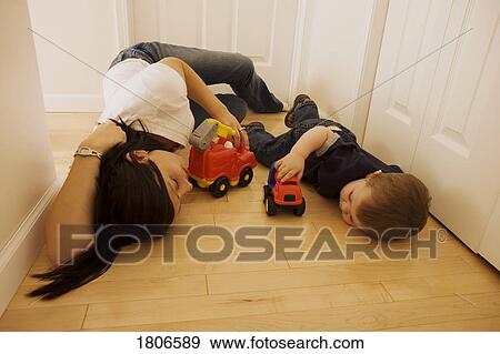 Mother and son laying on the floor playing with toys View Large Photo Image Stock Photo - Mother and son laying on the floor playing with toys. Fotosearch