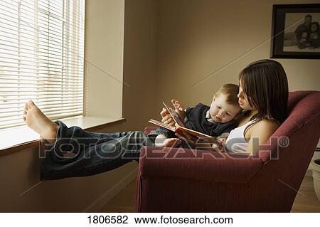 Mother holding child and reading to him View Large Photo Image Stock Image - Mother holding child and reading to him. Fotosearch