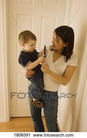 Mother holding son with cell phone View Large Photo Image Stock Image - Mother holding son with cell phone. Fotosearch