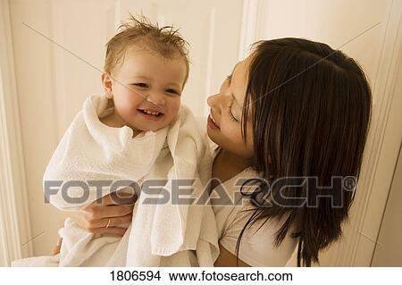 Picture - Mother smiling and holding boy. Fotosearch