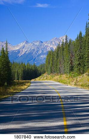 Stock Image - Mountain road with morning shadows, Jasper National Park, Alberta, Canada. Fotosearch