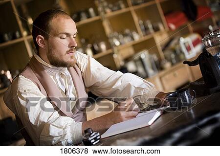 Stock Photo - Side view of a man writing notes. Fotosearch