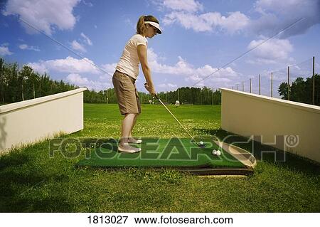 Stock Photo - Side view of a woman playing golf. Fotosearch
