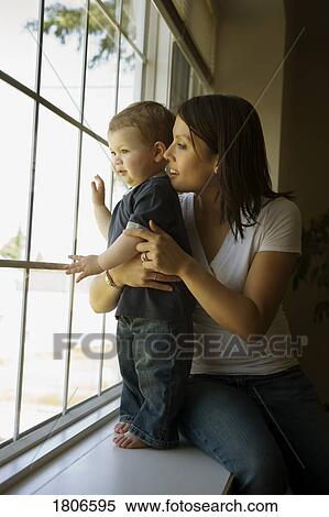 Stock Photography - Side view of mother sitting with son. Fotosearch