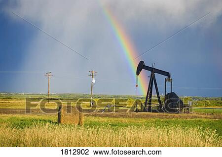 Storm clouds and rainbow over prairie oil pump View Large Photo Image Stock Image - Storm clouds and rainbow over prairie oil pump . Fotosearch