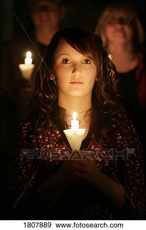 Stock Photo - Teen girl at candle light ceremony. Fotosearch