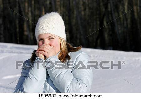 Stock Image - Teenager warming her hands. Fotosearch