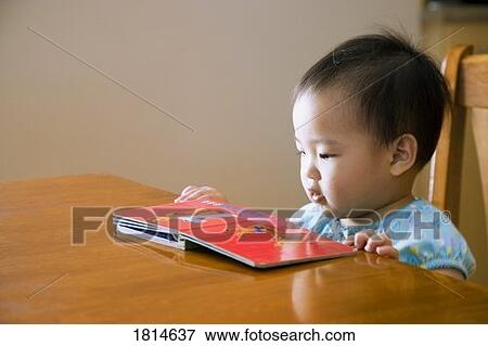 Toddler looking at a book View Large Photo Image Stock Photo - Toddler looking at a book. Fotosearch