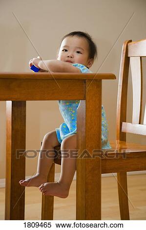 Stock Photography - Toddler sitting at table. Fotosearch