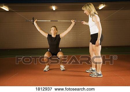 Stock Photo - Two women working with weights. Fotosearch