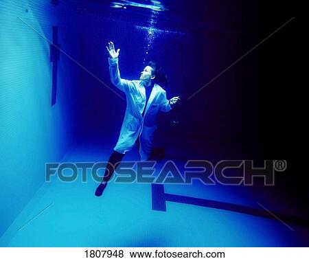 Stock Photo - Woman dressed as a doctor under water. Fotosearch