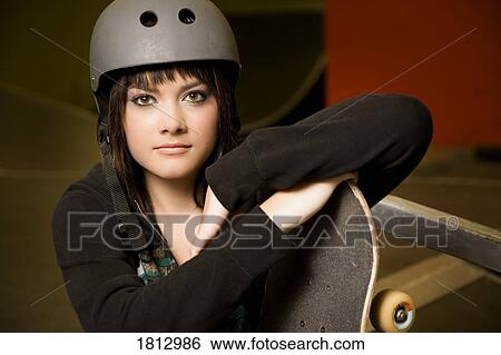 Woman holding a skateboard View Large Photo Image Stock Photograph - Woman holding a skateboard. Fotosearch