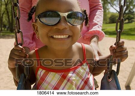 Young girl smiling on swing at the park View Large Photo Image Picture - Young girl smiling on swing at the park. Fotosearch