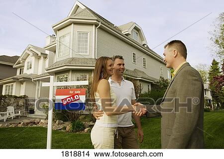 Picture - A couple shaking hands with a realtor. Fotosearch