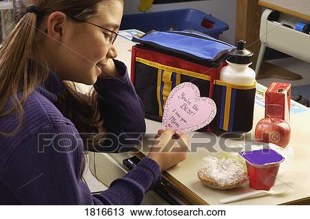 Stock Image - A girl reading a Valentine. Fotosearch