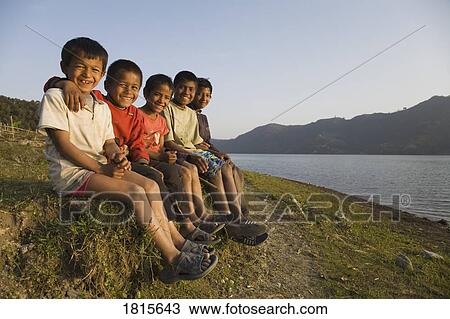 A group of boys sitting on a hill View Large Photo Image Stock Image - A group of boys sitting on a hill. Fotosearch