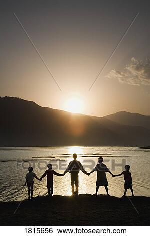 Stock Photograph - A group of people holding hands. Fotosearch