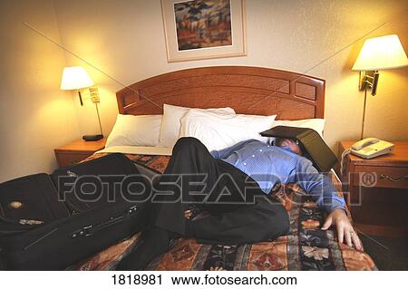 A man asleep on a bed in a hotel room View Large Photo Image Stock Image - A man asleep on a bed in a hotel room. Fotosearch