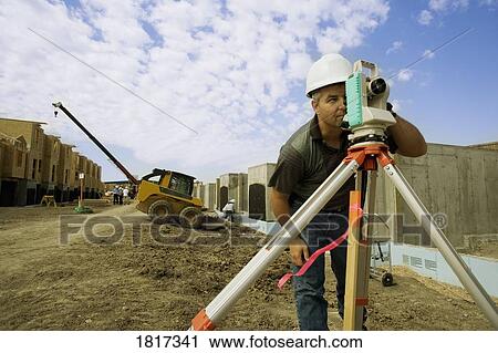 A surveyor at a construction site View Large Photo Image Stock Image - A surveyor at a construction site. Fotosearch
