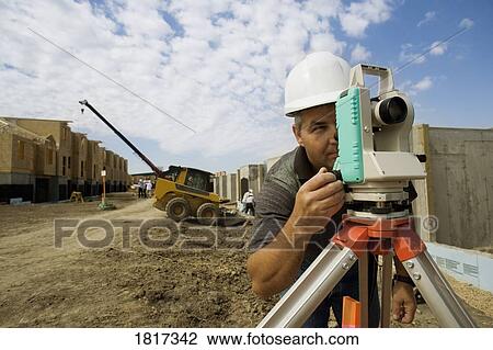 Stock Image - A surveyor at a construction site. Fotosearch