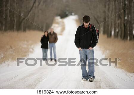 Picture - A teenage boy walking away from his parents. Fotosearch