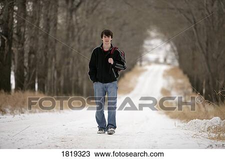 A teenage boy walking on a snow-covered path View Large Photo Image Stock Image - A teenage boy walking on a snow-covered path. Fotosearch