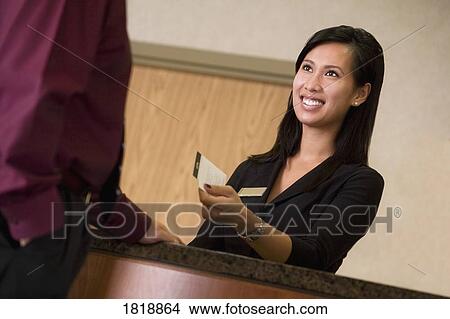 A woman at a hotel desk View Large Photo Image Picture - A woman at a hotel desk. Fotosearch