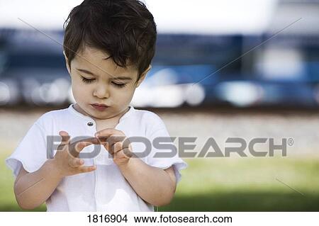 Picture - Boy looking at fingers . Fotosearch