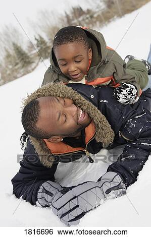 Father and son playing on snow View Large Photo Image Stock Photograph - Father and son playing on snow. Fotosearch