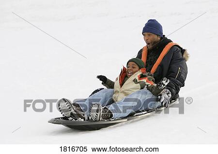 Stock Photography - Father and son sledding on snow. Fotosearch