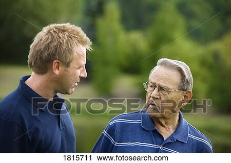 Stock Image - Father and son walking outside. Fotosearch