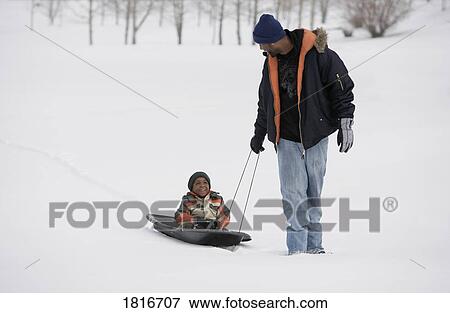 Father pulling son on sled View Large Photo Image Stock Photo - Father pulling son on sled. Fotosearch
