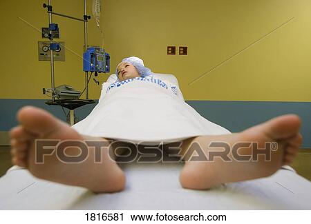 Stock Image - Female patient lying on an operating table . Fotosearch