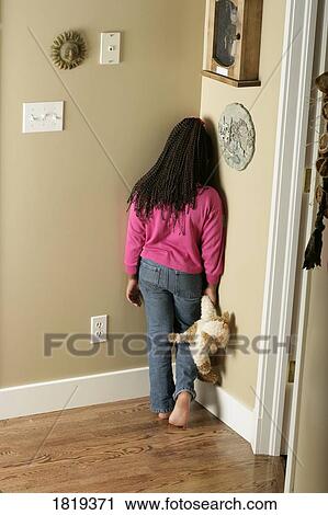Stock Image - Girl standing in the corner. Fotosearch
