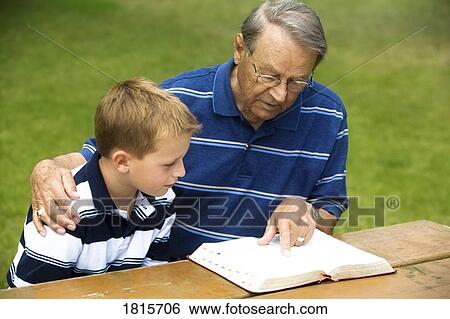 Grandfather and grandson reading the Bible View Large Photo Image Stock Photograph - Grandfather and grandson reading the Bible. Fotosearch