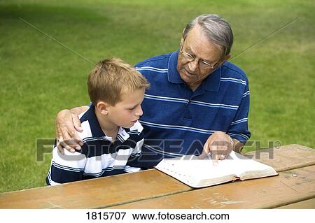 Grandpa and grandson reading the Bible View Large Photo Image Stock Photo - Grandpa and grandson reading the Bible. Fotosearch