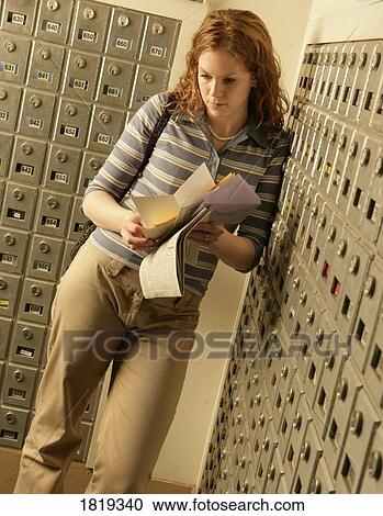 Stock Image - Lady opening mail at mailboxes. Fotosearch