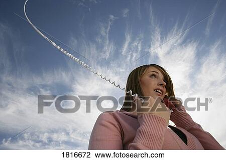 Low angle view of woman talking on phone View Large Photo Image Stock Image - Low angle view of woman talking on phone. Fotosearch