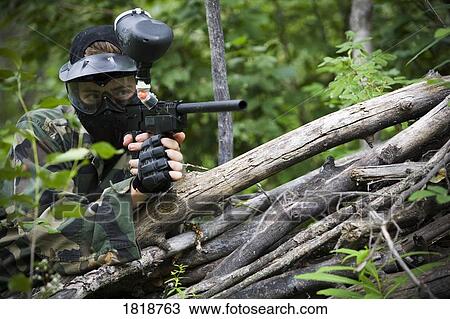 Stock Image - Male aiming a paintball gun. Fotosearch
