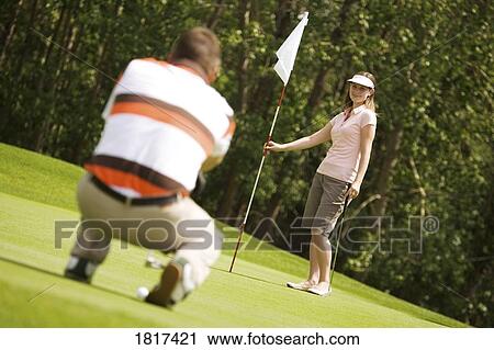 Stock Image - Man and woman golfing. Fotosearch