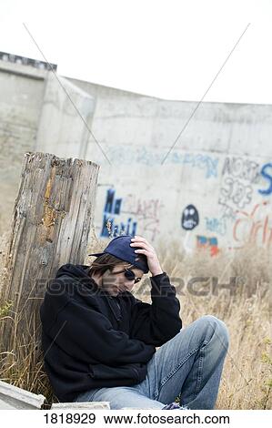 Man sitting by graffiti View Large Photo Image Stock Photo - Man sitting by graffiti. Fotosearch