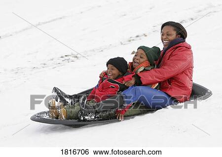 Stock Photograph - Mother and children sledding on snow. Fotosearch