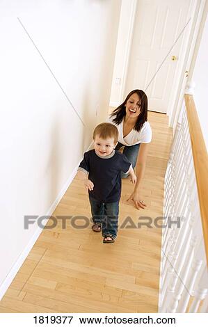 Mother chasing her son down a hallway View Large Photo Image Stock Photo - Mother chasing her son down a hallway. Fotosearch
