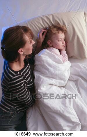 Mother watching daughter sleep View Large Photo Image Stock Photo - Mother watching daughter sleep. Fotosearch