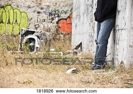 Stock Photograph - Person beside graffiti. Fotosearch