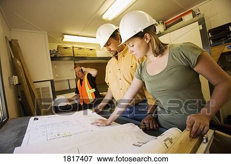 Reviewing blueprints View Large Photo Image Stock Photo - Reviewing blueprints. Fotosearch