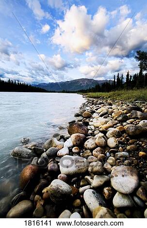 River with rocky shore and mountains in background View Large Photo Image Stock Image - River with rocky shore and mountains in background. Fotosearch
