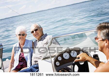 Stock Image - Senior couple and man in a speed boat. Fotosearch