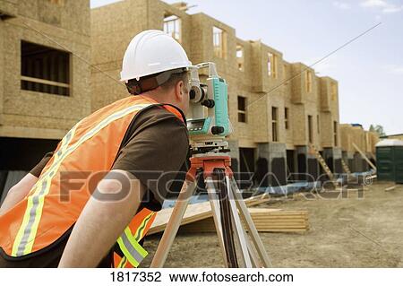 Stock Image - Surveyor on construction site. Fotosearch