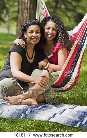 Two women sitting together View Large Photo Image Stock Photo - Two women sitting together. Fotosearch